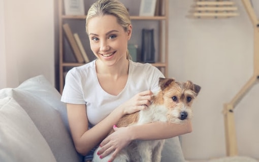 Jeune femme souriante tenant un petit chiot